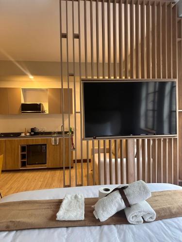 a bedroom with a large television and two towels on a bed at CasaSue Living & Hotel in Bogotá