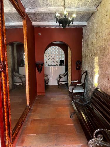 a hallway with a mirror and a bench in a room at Hotel Galeria la Trinidad in Cartagena de Indias