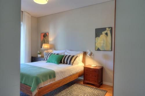 a bedroom with a bed and a table with a night stand at Mouzinho50 - Elegant Apartment in Póvoa de Varzim