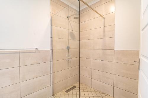 a bathroom with a shower with tiled walls at Cozy Cove St Helena in West Point
