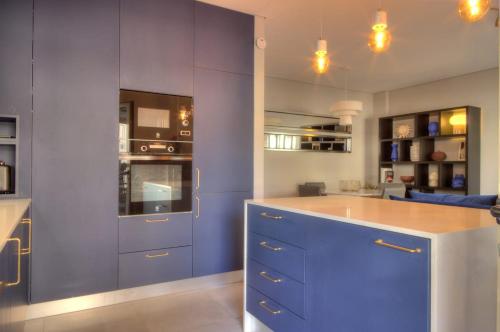 a kitchen with blue cabinets and a blue island at Mouzinho50 - Elegant Apartment in Póvoa de Varzim