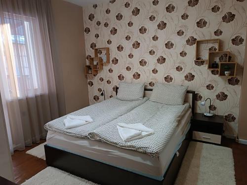 a bedroom with a bed and a floral wall at Guest House Марковата Къща in Madzhare