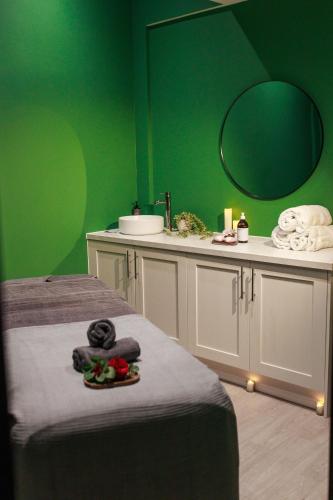 a green room with a bed and a sink at Blackwell Grange Hotel in Darlington