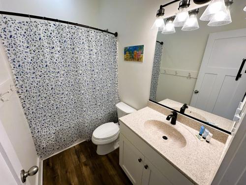 a bathroom with a sink and a toilet and a shower at KD1730 - Cole's Cabana in Kill Devil Hills