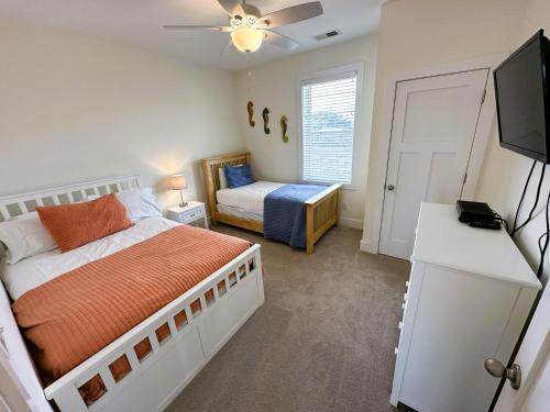 a bedroom with a bed and a flat screen tv at KD1730 - Cole's Cabana in Kill Devil Hills