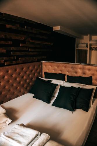 a bed with white sheets and green pillows at Sir Thomas Bed Central in Bolzano