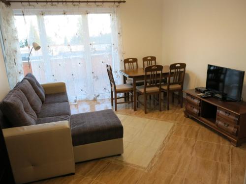 een woonkamer met een bank en een eettafel bij Apartments Victoriya in Sutomore