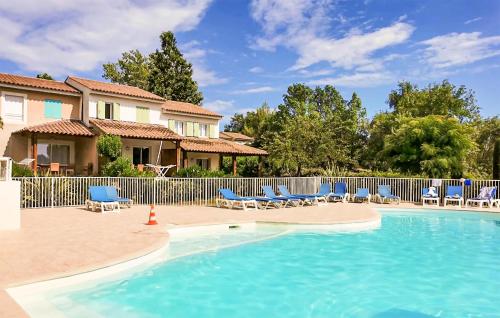 a swimming pool with chairs and a fence at Maison 1 in Montauroux