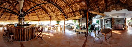 een grote kamer met een groot rieten dak bij Auberge Le Maki Lodge in Ampangorinana
