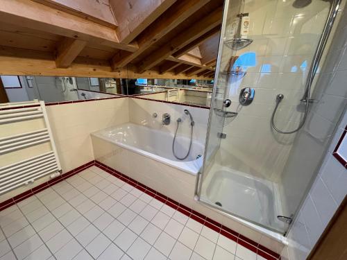 a bathroom with a shower and a bath tub at Alpen Apartment "Ruhe & Erholung" in Oberammergau