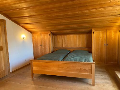 a bed in a room with a wooden ceiling at Alpen Apartment "Ruhe & Erholung" in Oberammergau