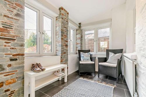 a room with two chairs and a bench and windows at 2 Bed in Wadebridge oc-r27444 in Little Petherick