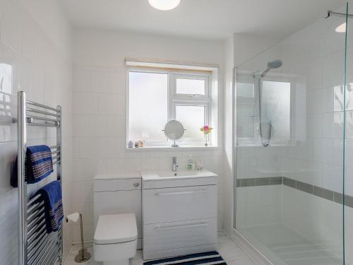 a white bathroom with a sink and a shower at 4 Bed in Mablethorpe oc-77958 in Sutton on Sea