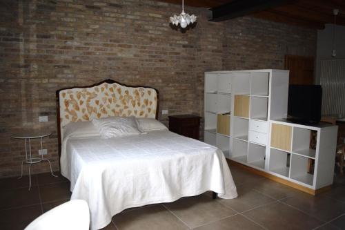 a bedroom with a bed and a brick wall at da Gastone in Rivignano