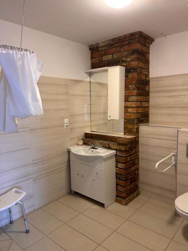 a bathroom with a sink and a brick wall at Agroturystyka Maya in Gorzyca