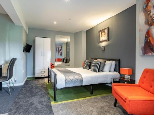 a bedroom with a bed and a couch and a chair at 9 Bed in Ipswich oc-62352 in Freston