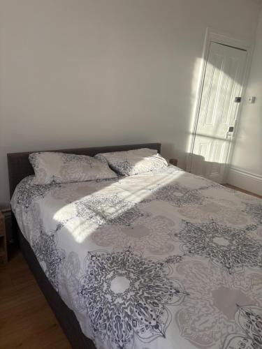 a bed with a blanket and pillows on it at Crystal in Crystal Palace