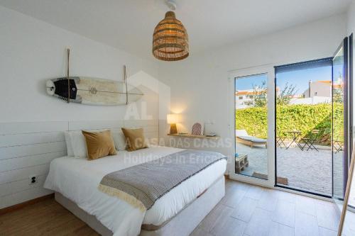 a bedroom with a bed and a large window at Valentin House by ACasaDasCasas in Santo Isidoro