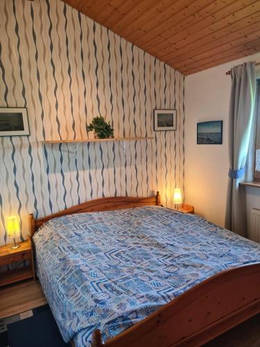 a bedroom with a wooden bed with a blue comforter at Haus Austernfischer in Schweiburg