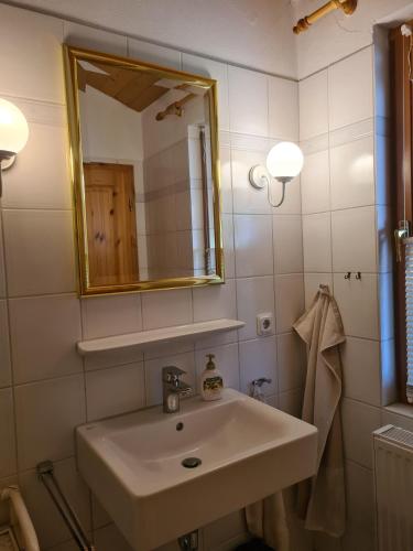 a bathroom with a sink and a mirror at Haus Austernfischer in Schweiburg
