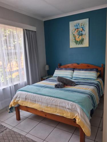 a bedroom with a bed with a blue wall at Stop-a-While in Krugersdorp