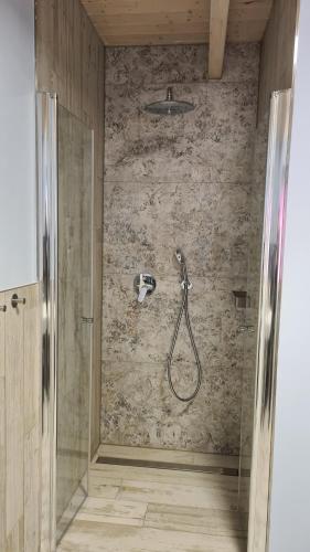 a shower in a bathroom with a stone wall at Haus Lüchtje Jade in Sehestedt