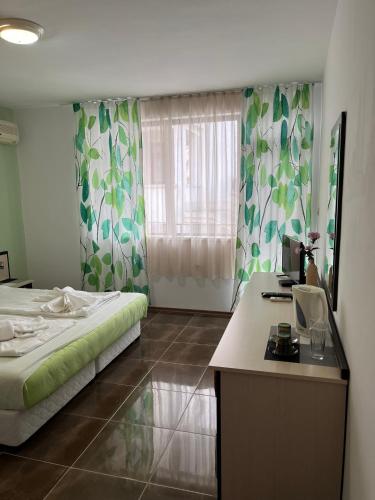 a bedroom with a bed and a desk and a window at kaLe in Ravda