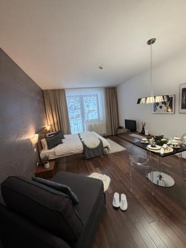 a bedroom with a bed and a living room at Apartmán Deluxe Jasná in Belá