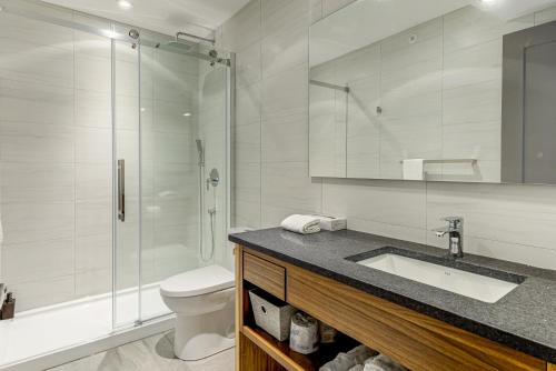 a bathroom with a toilet and a sink and a shower at 77 St-Vallier Apparts Hôtel in Quebec City