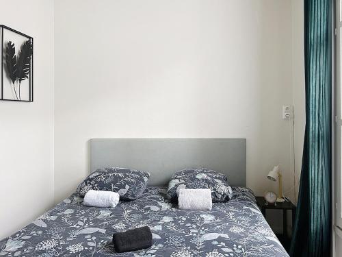 a bed with two pillows on it in a bedroom at Le Antoine in Compiègne
