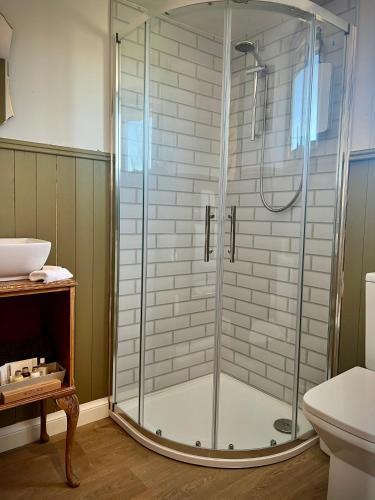 a shower with a glass door in a bathroom at Cabin on the Moors in Llansannan