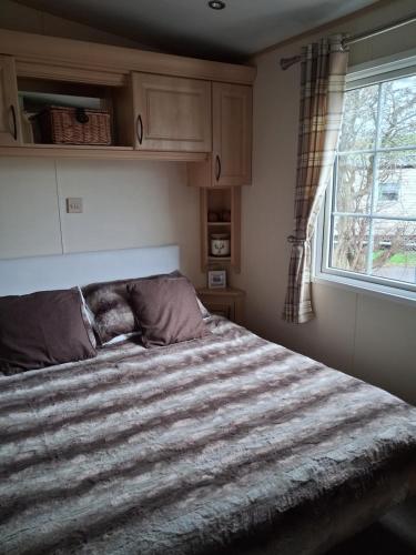 a bedroom with a large bed with a window at St Nicholas Number 5 in Turnberry