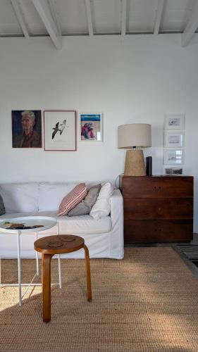 a living room with a white couch and a table at Casas do Horizonte in Ribeiras