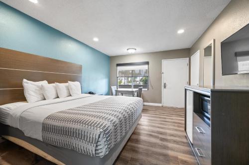 a hotel room with a bed and a television at Hotel Palmeras Chula Vista in Chula Vista
