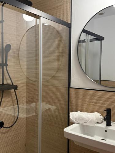 a bathroom with a shower and a sink and a mirror at Apartamentos Turísticos La Terraza* in Las Cabezas de San Juan