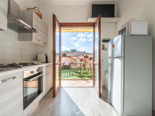 a kitchen with a door open to a patio at Estay - Maria's Wonderful Retreat in Villasimius