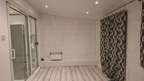a bathroom with a shower and a glass wall at The White House in Moston