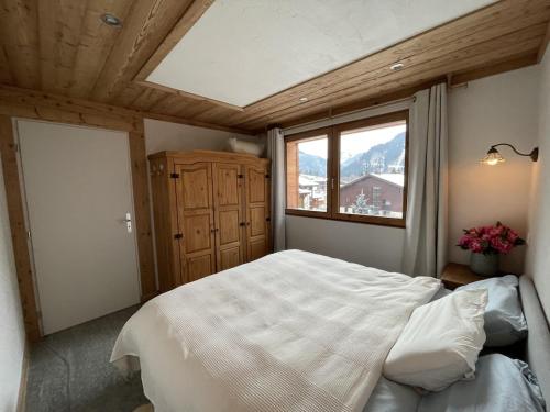 Chalet Sablod في لي كونتامين مونتجوا: غرفة نوم بها سرير كبير ونافذة