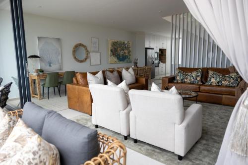 a living room with two white chairs and a couch at Oceana View at Oceans 3 Selfcatering Holiday Home in Rand Rifles