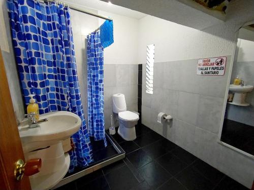 a bathroom with a sink and a blue shower curtain at Casa Campestre Villa Alejandra in La Tebaida