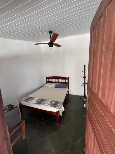 a room with a bed and a ceiling fan at Cantinho do tricolor in Saquarema