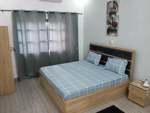 una camera da letto con un letto con un piumone blu di Chez Yenou a Cotonou