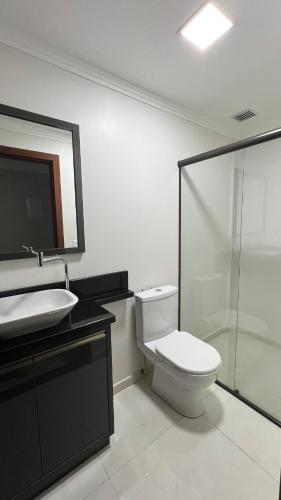 a bathroom with a toilet and a sink and a shower at Apartamento em Pomerode - 205 in Pomerode