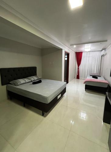 a bedroom with two beds and a red curtain at Apartamento em Pomerode - 205 in Pomerode