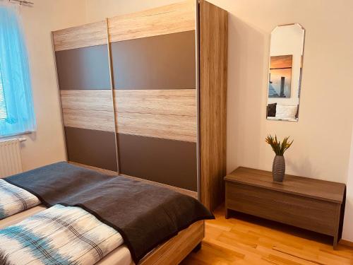 a bedroom with a bed with a wooden headboard at Appartement Gombotz in Halbenrain