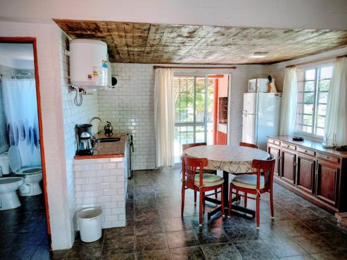 a kitchen with a table and chairs and a refrigerator at El Encuentro in Piriápolis