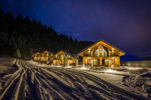 a house in the snow at night with lights at Chalety v Pieninách in Červený Kláštor