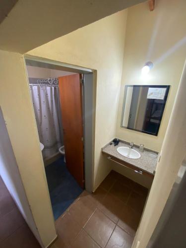 a bathroom with a sink and a mirror at Balcón del Cerro Cabañas in La Falda