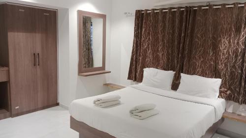a bedroom with a large bed with two slippers on it at Hotel Aishwarya in Pandharpur