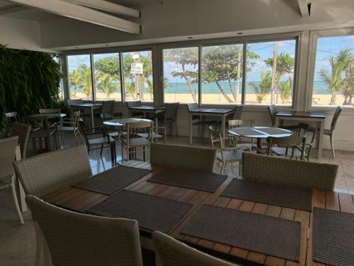 a restaurant with tables and chairs and a view of the beach at Hotel Barramares in Recife